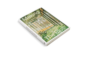 Schrägansicht des Buches Making The Plus auf einem weißen Hintergrund. Das Cover zeigt eine Fotografie des lichtdurchfluteten Innenraums eines modernen Gebäudes mit grüner Trägerkonstruktion und Blick durch große Fenster auf einen Wald.
