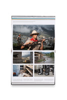 Ein aufgeschlagenes Fotobuch zeigt eine Doppelseite mit einer Fotocollage. Oben ist ein großes Bild von zwei uniformierten Milizionären mit Gewehren vor einer Stadtkulisse. Darunter befinden sich vier kleinere Bilder: eine Stadtansicht mit Hochhäusern, eine Person, die einen Fluss unter einer Brücke überquert, eine Ansicht moderner Betonarchitektur von oben und eine Festnahme einer Person durch Polizisten in Schutzausrüstung.