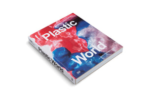 Der Ausstellungskatalog Plastic World liegt in Schrägansicht auf weißem Grund. Das Cover zeigt eine abstrakte Grafik mit roten und blauen Farbverläufen, darüber der Titel in großen, weißen Buchstaben.