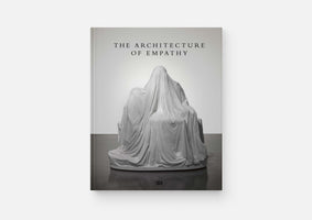 Das Buchcover von The Architecture of Empathy zeigt eine in Schwarz-Weiß gehaltene Fotografie einer Skulptur. Die Skulptur stellt eine sitzende, vollständig von einem weißen Tuch verhüllte Figur auf einem Thron dar.