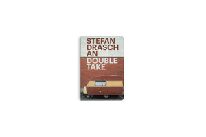Ein Buch mit dem Titel Stefan Drasch, An Double Take. Auf dem Cover ist ein brauner und beiger Wohnwagen vor einer roten Backsteinmauer abgebildet.