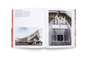 Ein aufgeschlagenes Fotobuch mit dem Titel building narratives. Links ist die Außenansicht eines modernistischen Betongebäudes abgebildet. Rechts posieren maskierte Performer in weiß-gelben Kostümen auf einer Empore in einem Stadion mit leeren Rängen über einem Marmoreingang.