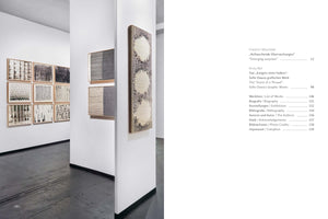 Eine aufgeschlagene Seite eines Kunstkatalogs. Links eine Fotografie einer Galerie mit abstrakten, schwarz-weißen Kunstwerken an weißen Wänden. Rechts das Inhaltsverzeichnis mit Titeln und Seitenzahlen auf Deutsch und Englisch.