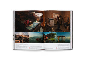 Ein aufgeschlagenes Fotobuch zeigt eine Doppelseite mit einer Fotoreportage. Die Bilder dokumentieren das Leben von Menschen in einfachen Verhältnissen, darunter ein schlafendes Mädchen in einem Bett, eine Mutter mit Kind in einer Hütte und verschiedene Szenen am Wasser. Unter den Fotos stehen deutsche Bildunterschriften.