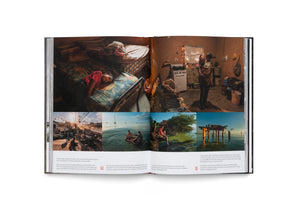 Ein aufgeschlagenes Fotobuch zeigt eine Doppelseite mit einer Fotoreportage. Die obere Hälfte wird von zwei großen, stimmungsvollen Fotos von Menschen in einfachen Innenräumen eingenommen. Darunter befinden sich mehrere kleinere Bilder, die Szenen am Wasser und in einer städtischen Umgebung darstellen, jeweils mit englischen Bildunterschriften versehen.