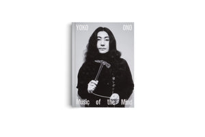 Das schwarz-weiße Cover des Buches Yoko Ono: Music of the Mind. Es zeigt ein Porträt von Yoko Ono mit dunklem Rollkragenpullover, die einen gläsernen Hammer hält und direkt in die Kamera blickt.
