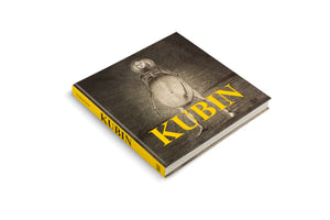 Ein quadratisches Kunstbuch mit dem Titel KUBIN liegt schräg auf einem weißen Hintergrund. Das dunkle Cover zeigt eine unheimliche Zeichnung einer teils skelettierten Figur mit einem großen Bauch. Der Titel ist in markanten gelben Buchstaben aufgedruckt. Der Buchrücken ist ebenfalls gelb.
