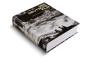 Ein dickes Buch mit dem Titel Der Deutsche Film. Das schwarz-weiße Cover zeigt eine Filmcrew bei Dreharbeiten in einer schneebedeckten Berglandschaft. Das Buch liegt schräg auf einer weißen Oberfläche.