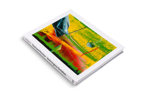 Ein weißes, gebundenes Buch mit dem Titel Gerhard Richter Verborgene Schätze liegt schräg auf einer weißen Fläche. Das Cover zeigt ein farbenfrohes, abstraktes Gemälde mit kräftigen Pinselstrichen in Gelb, Grün, Rot und Blau.