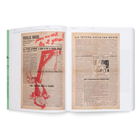 Ein aufgeschlagenes Buch, das Reproduktionen von zwei vergilbten, antifaschistischen französischen Zeitungsseiten aus den 1930er Jahren zeigt. Die linke Seite, Feuille Rouge, hat eine große rote Grafik, die einen Galgen und kämpfende Figuren darstellt. Die rechte Seite, La torche entre les dents, besteht hauptsächlich aus Text.