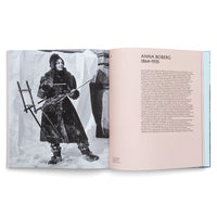 Ein aufgeschlagenes Buch zeigt auf der linken Seite eine Schwarz-Weiß-Fotografie der Künstlerin Anna Boberg. Sie steht in dicker Winterkleidung mit einer Staffelei im Schnee. Die rechte Seite enthält eine Biografie über sie mit der Überschrift ANNA BOBERG 1864-1935.