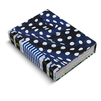 Ein Buch mit einem dunkelblauen Einband, der mit unregelmäßigen weißen Punkten gemustert ist. Der Buchrücken hat schwarze und weiß-blau gestreifte vertikale Bänder und trägt den neongrünen Schriftzug alia ali. Das Buch liegt schräg auf einem weißen Hintergrund.