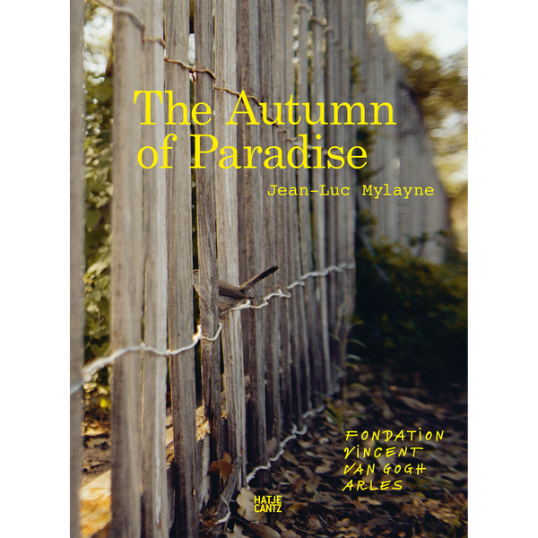 Ein kleiner Vogel sitzt auf dem Draht eines verwitterten Holzzauns auf dem Buchcover von The Autumn of Paradise von Jean-Luc Mylayne.