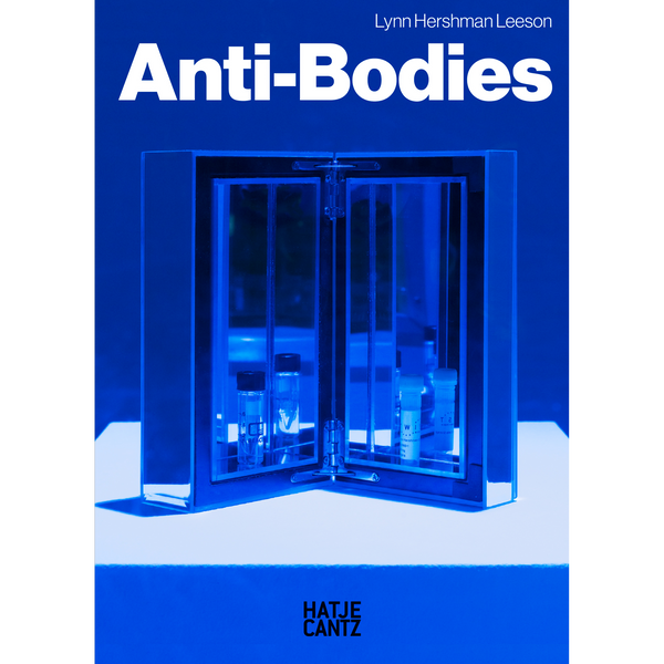 Das leuchtend blaue Cover des Buches Anti-Bodies von Lynn Hershman Leeson zeigt einen kleinen, geöffneten Kasten, der Laborfläschchen enthält.