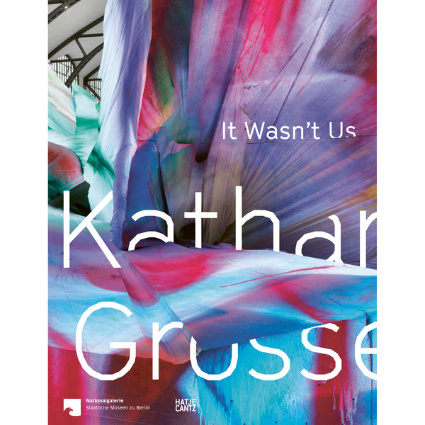 Das Cover des Katalogs Katharina Grosse, It Wasn't Us, zeigt einen Ausschnitt einer raumgreifenden Installation, die mit leuchtenden Farben in Pink, Blau und Violett besprüht wurde.