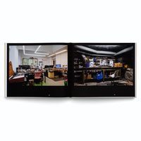 Ein aufgeschlagenes Buch, das auf einer Doppelseite zwei kontrastierende Fotos von Werkstätten zeigt. Links ein helles, modernes Büro mit Schreibtischen und Elektronik, rechts eine dunkle Kellerwerkstatt mit einer Werkbank unter Rohren.