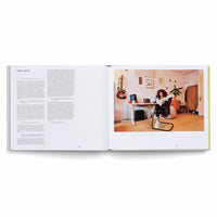 Ein aufgeschlagenes Buch auf weißem Hintergrund, das auf der linken Seite ein Interview mit Sarah Farina und auf der rechten Seite ein Foto von ihr in ihrem Musikstudio zeigt, wo sie an einem Schreibtisch sitzt.