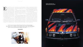 Doppelseite eines Magazins über den Künstler Ernst Fuchs. Links befindet sich Text mit einem Zitat und einem kleinen Foto des Künstlers. Rechts dominiert die Frontansicht eines von Fuchs gestalteten BMW 635CSi, dessen schwarze Karosserie mit großen, lodernden Flammen in Rot, Orange und Blau bemalt ist.