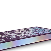 Nahaufnahme eines geschlossenen Buches mit einem dunkelvioletten Einband, der ein holografisches Muster aus stilisierten Buchstaben aufweist. Die Seitenkanten des Buches sind ebenfalls holografisch und schimmern in Regenbogenfarben vor einem weißen Hintergrund.