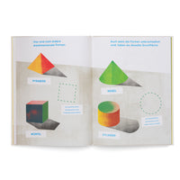 Ein aufgeschlagenes Buch mit Illustrationen von dreidimensionalen Formen. Die linke Seite zeigt eine Pyramide und einen Würfel und dazwischen die gestrichelte Kontur ihrer gemeinsamen quadratischen Grundfläche. Die rechte Seite zeigt einen Kegel und einen Zylinder mit der gestrichelten Kontur ihrer gemeinsamen kreisförmigen Grundfläche. Deutscher Text beschriftet die Formen und erklärt die Zusammenhänge.