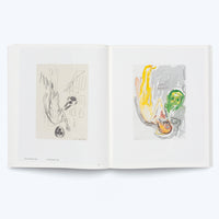 Ein aufgeschlagenes Kunstbuch auf einer weißen Fläche, das zwei Seiten mit expressionistischen Zeichnungen zeigt. Links ist eine Schwarz-Weiß-Strichzeichnung einer umgedrehten Figur, rechts ein farbiges Aquarell einer gelben, umgedrehten Figur neben einem grünen Gesicht.